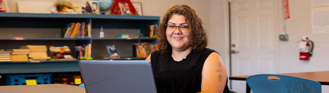 A student works in a Pima library with her laptop